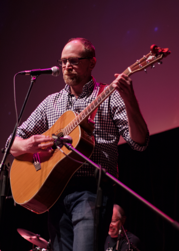 guitar teacher helping student