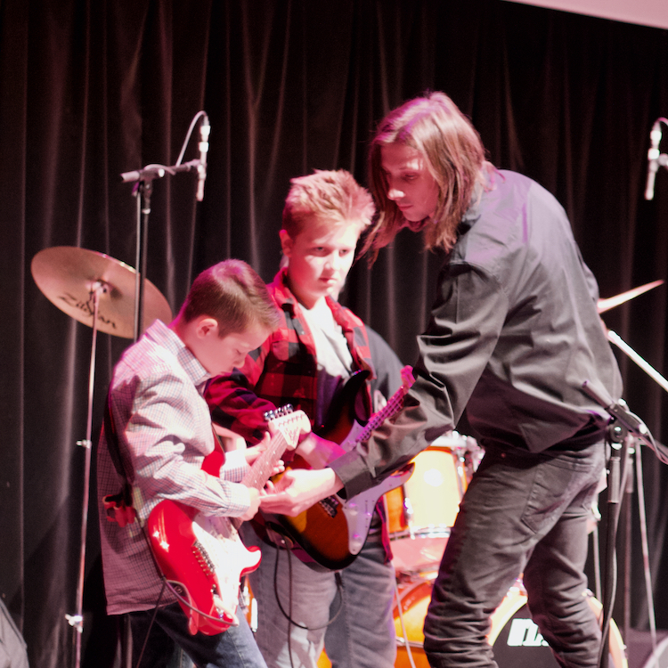 guitar teacher helping student