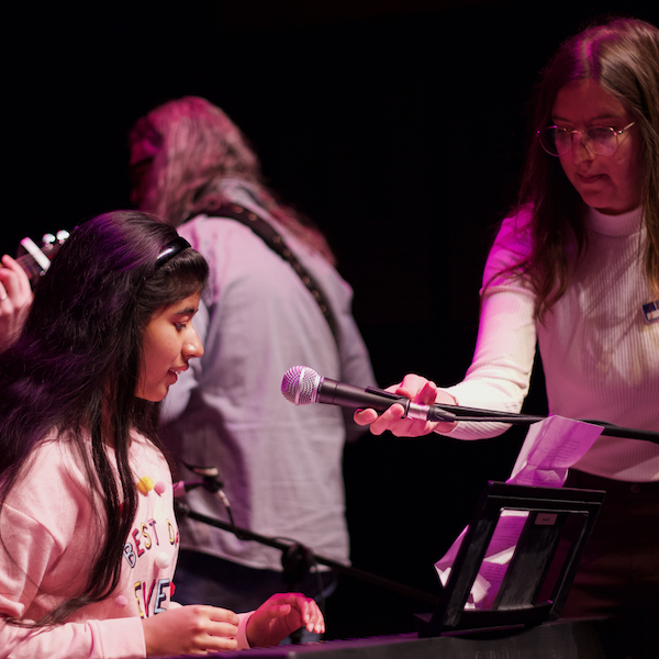 piano teacher helping student